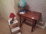a small table with a lamp and a globe on it