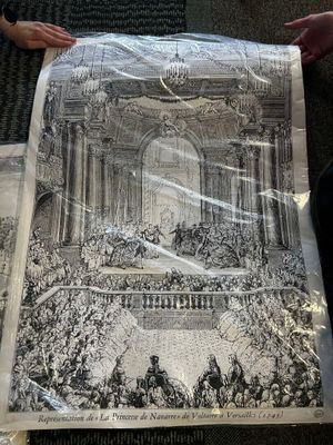 a person holding up a newspaper with a drawing on it