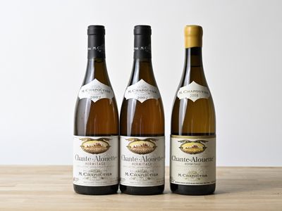 trois bouteilles de vin posées sur une table en bois