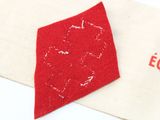 a red piece of fabric on top of a white bag