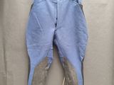 Le pantalon est bleu et gris, avec un empiècement marron sur le côté.