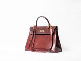 a brown handbag sitting on top of a white surface