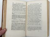 an open book with a hand holding it in front of a white background