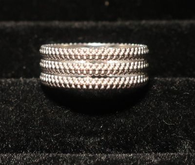 un gros plan d'une bague en argent posée sur une surface en velours