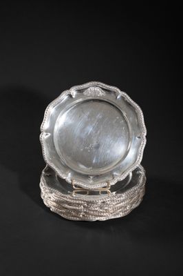 two silver plates on a stand on a black background