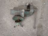 an old viset on the ground next to a piece of metal