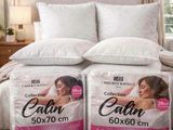 deux oreillers posés sur un lit dans une chambre, près d'une fenêtre