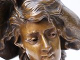 bronze statue of a woman with a hat on her head