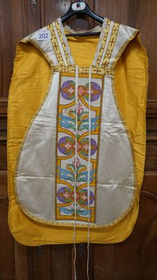 un gilet jaune et blanc accroché à une porte en bois