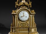 an image of a gold and white clock sitting on a table