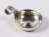 a silver spoon with a handle on a white surface