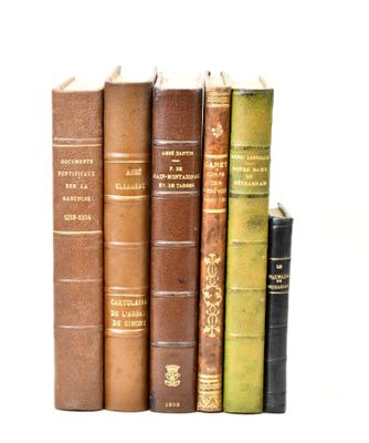 plusieurs vieux livres sont empilés sur une surface blanche