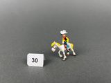 petite figurine représentant un homme à cheval à côté d'un panneau