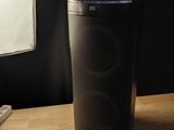 an image of a black speaker sitting on top of a wooden table