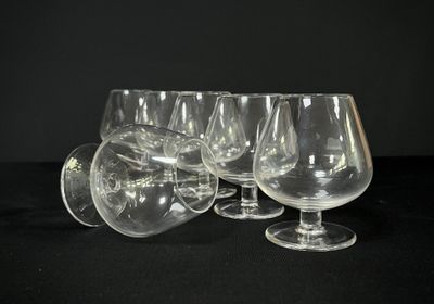 several empty wine glasses are lined up on a black surface