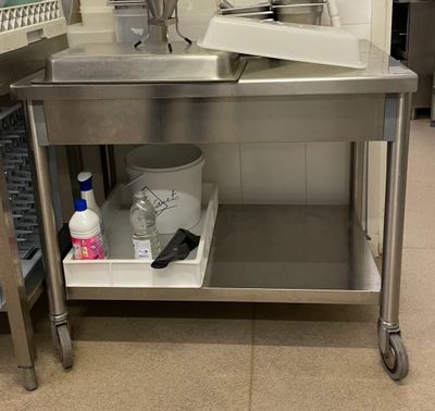 une table de travail en acier inoxydable équipée d'un évier et d'une poubelle