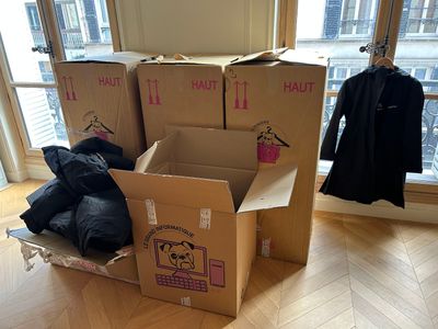 une pile de cartons posée par terre devant une fenêtre