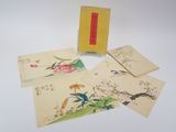 plusieurs cartes et enveloppes portant des inscriptions en chinois, posées sur une table