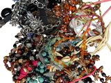 un tas de bracelets de toutes sortes posés sur une surface blanche