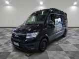 la camionnette noire est garée sur un sol en damier dans le garage