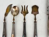 five spoons, a knife, and a knife on a table