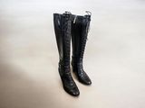 pair of black leather boots with zippers sitting on a white surface