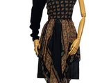 a mannequin wearing a dress on a wooden stand
