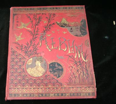 un livre rouge orné d'inscriptions dorées, posé sur une surface noire