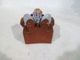 une petite figurine représentant un oiseau perché sur une boîte