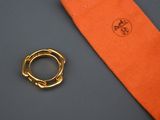 une cravate orange et une bague en or posées sur une table