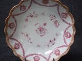 a white plate with a red and gold design on it