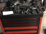 une boîte à outils rouge sur laquelle sont posés des outils, dans un garage