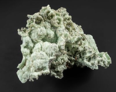 un gros plan sur un morceau de roche verte posé sur une surface noire