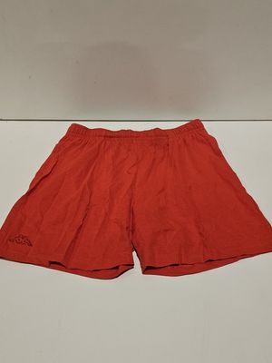 un gros plan sur un short rouge posé sur une surface blanche