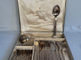 a silver case with silverware in it on a blue surface