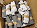 une boîte remplie de vêtements pliés, accompagnés d'étiquettes