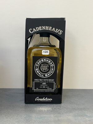 une bouteille de whisky posée sur une table à côté d'un coffret