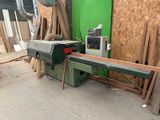 a machine that is cutting a piece of wood on a table