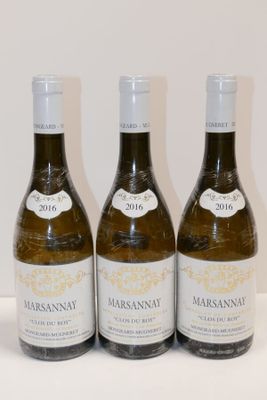 trois bouteilles de vin sont alignées sur une surface blanche