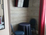 une chambre avec un lit, une chaise et une télévision fixée au mur