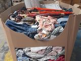 a cardboard box full of clothes and other items in a warehouse