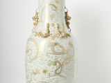 a white vase with gold designs on it on a table