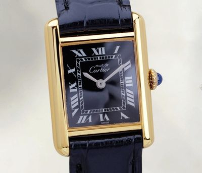 une image représentant une montre noire et dorée dont le cadran est orné de chiffres romains