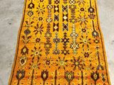 an orange and brown rug on a grey floor in a room