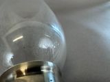 a glass bottle with a silver lid sitting on a table