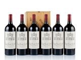 six bottles of red wine are lined up in front of a wooden box