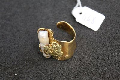an image of a gold and pearl ring with a tag on it