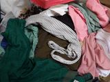 a pile of clothes in a suitcase with a hat on top