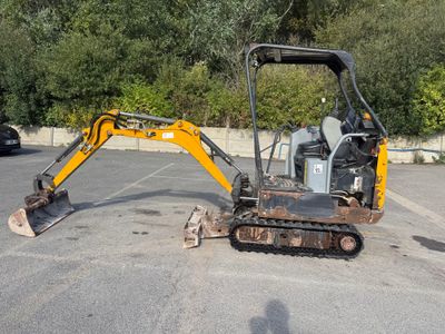 une petite excavatrice garée sur un parking