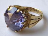 une image représentant une bague en or sertie d'une pierre violette